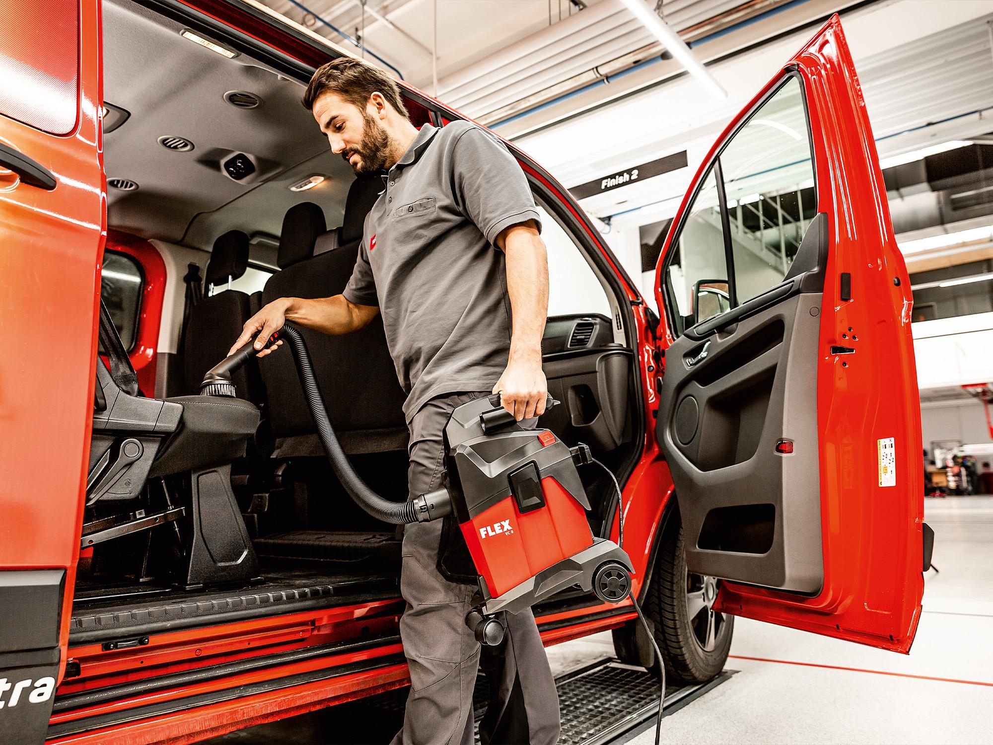 Vacuuming the interior of a car with a compact vacuum cleaner