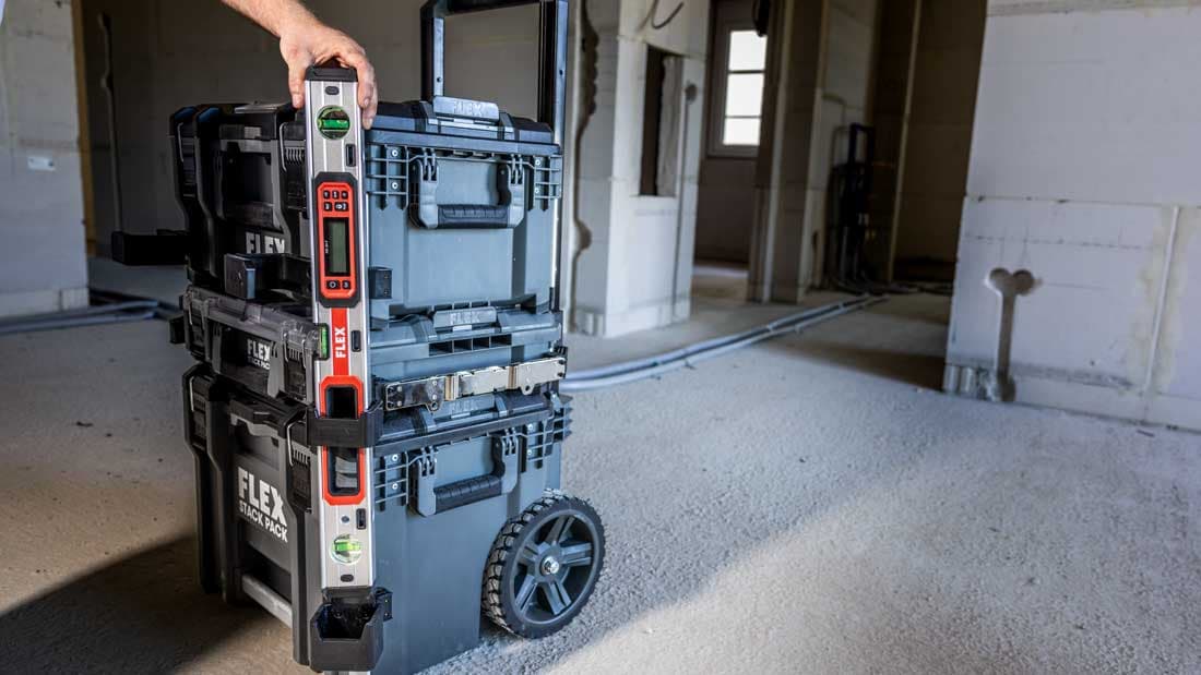 Systém prepravných kufrov STACK PACK™ s pripojenou vodováhou na stavenisku. Robustné a stohovateľné riešenie umožňuje bezpečnú organizáciu náradia a jednoduchú prepravu.