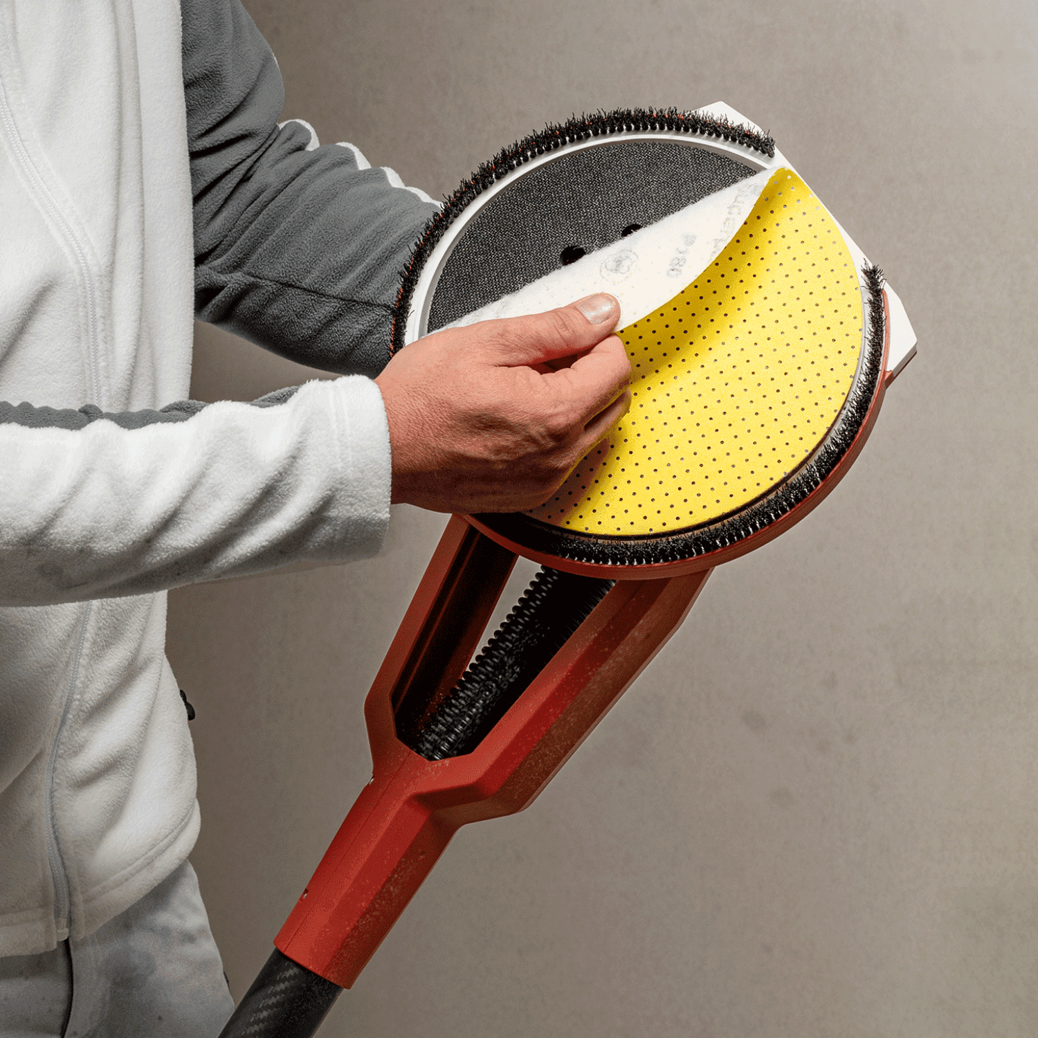 Hantverkare byter slippapper på FLEX GE 6 R långhalsad slipmaskin – perforerat slipmedel för effektiv dammutsugning.