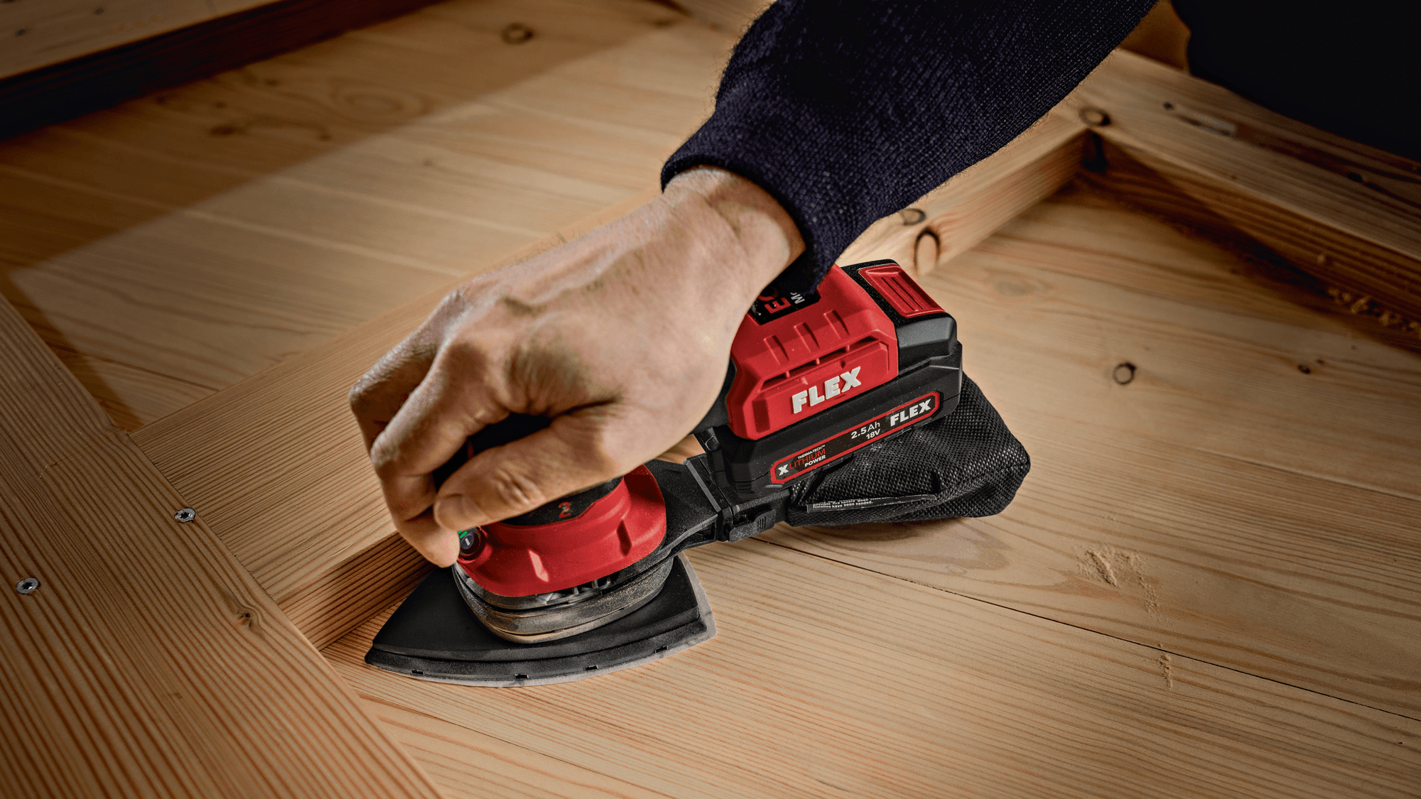 The corner of a piece of furniture is sanded with the FLEX cordless delta sander