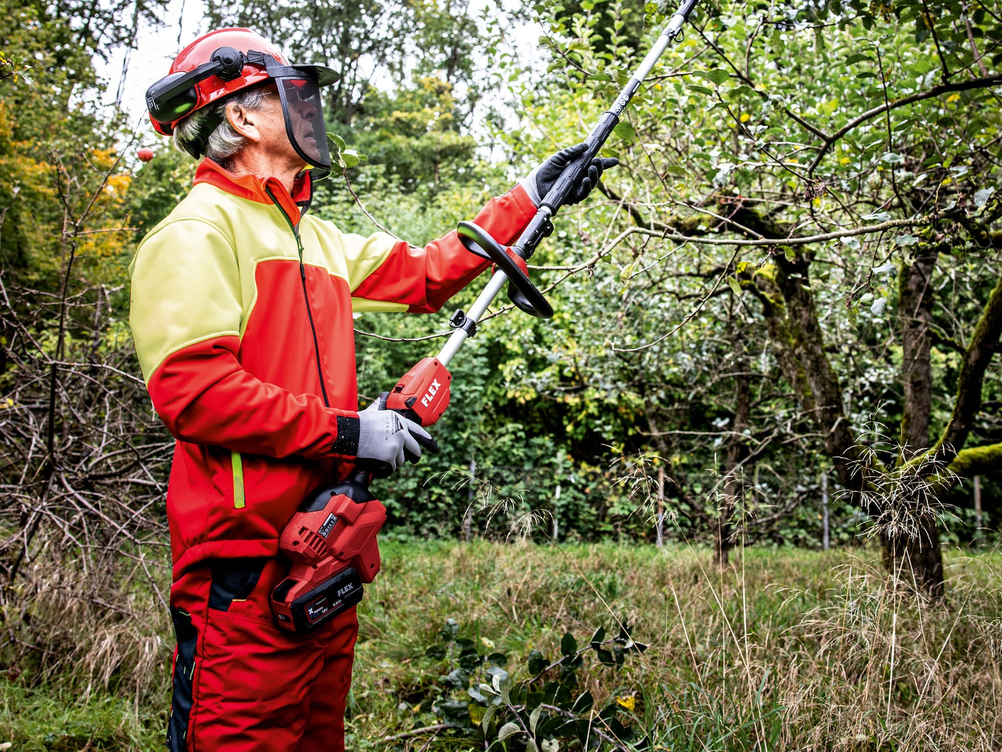 FLEX Akku-Basisantrieb mit Hochentaster-Vorsatz im Einsatz beim Schneiden von Ästen.