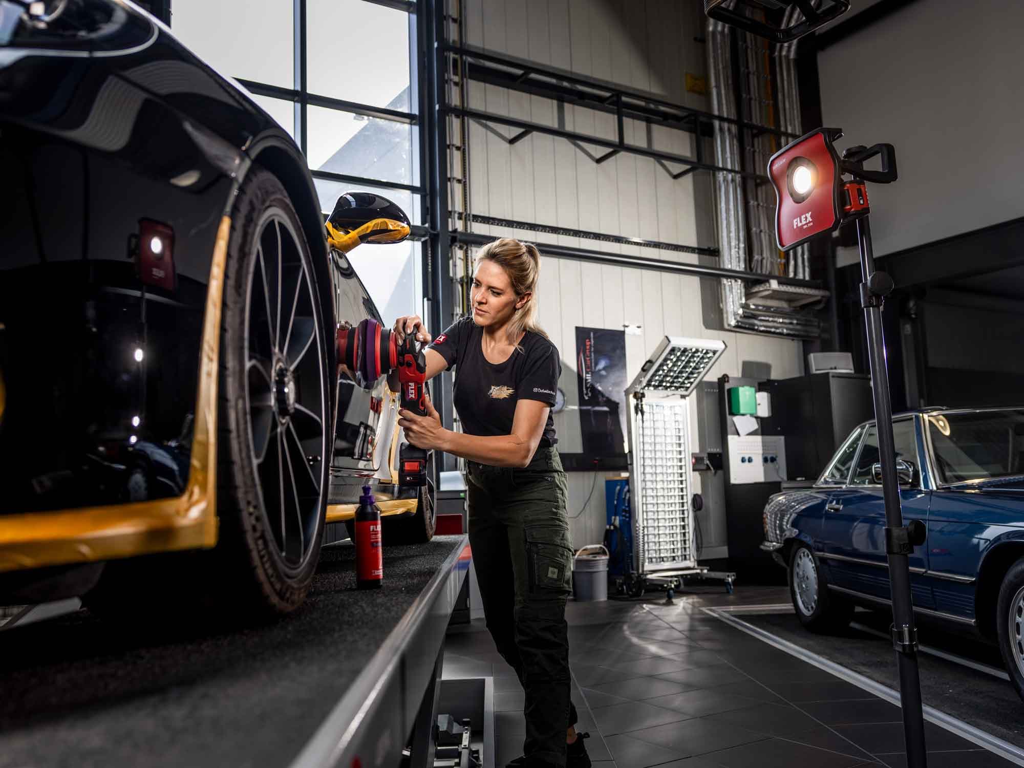 Επαγγελματίας στιλβωτής γυαλίζει μαύρο σπορ αυτοκίνητο με το ασύρματο έκκεντρο στιλβωτήριο FLEX