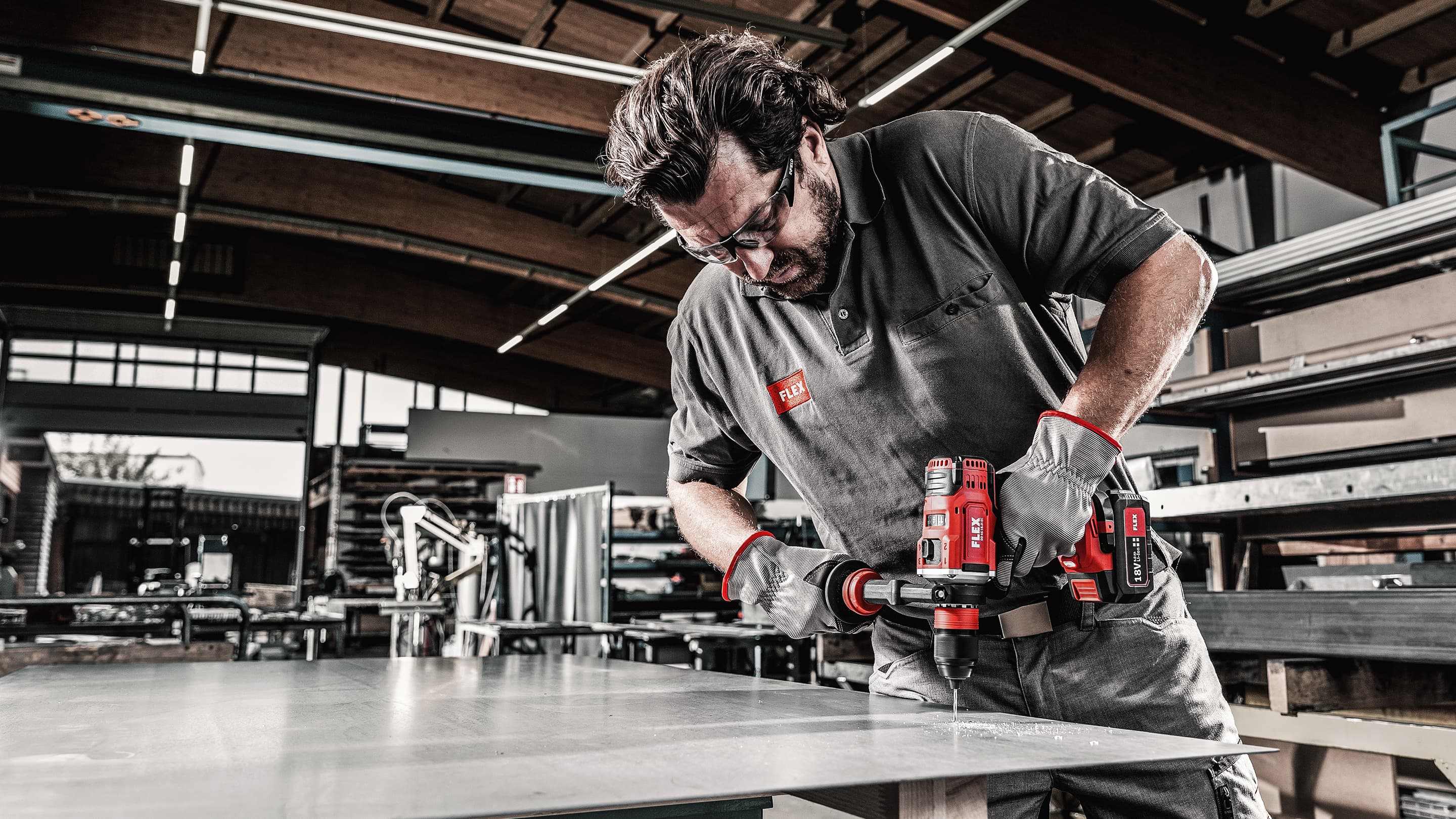 Vyvrtání malého otvoru do kovu v dílně pomocí aku vrtacího šroubováku FLEX