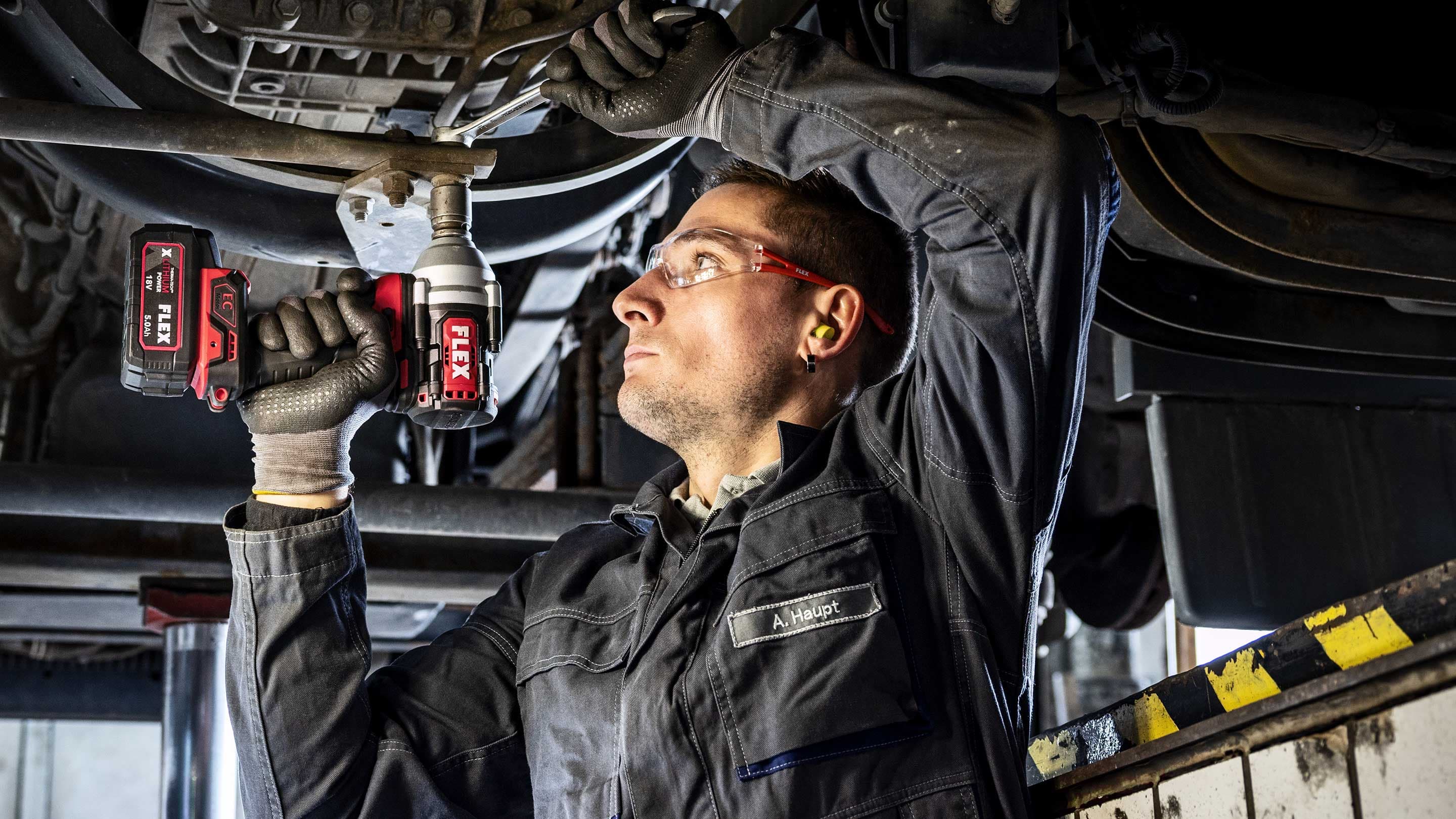KFZ-Werkstatt lösen einer Schraube am Fahrzeug-Unterboden mit FLEX Schlagschrauber