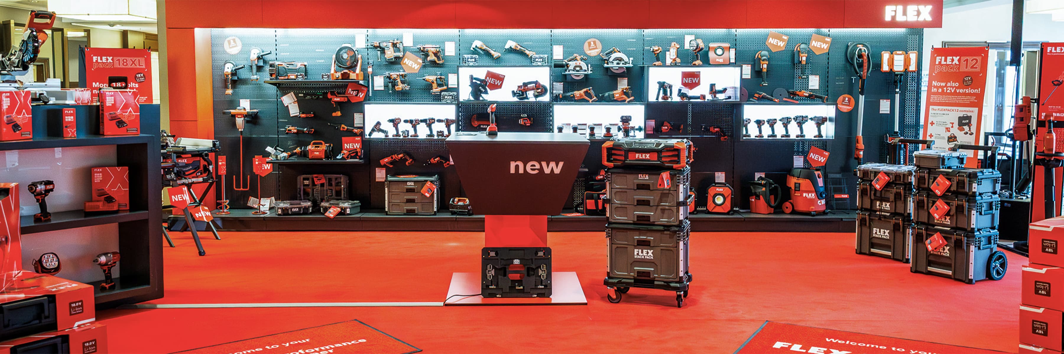 FLEX Messestand mit Akku-Werkzeugen in einer POS-Maschinenwand inkl. STACLPACK-System auf rotem Boden.